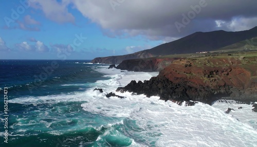 Panoramic shot of a rugged coastline with waves crashing against rocks under dramatic clouds. Perfect for adventure branding, coastal tourism, and environmental campaigns.