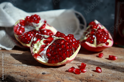 Fresh red pomegranate fruit on wooden cutting board.