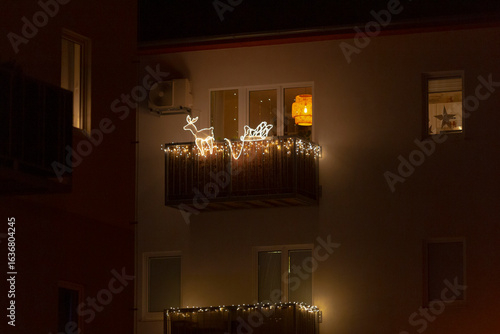 A beautifully decorated balcony adorned with sparkling Christmas lights is brightly illuminated during the enchanting hours of night