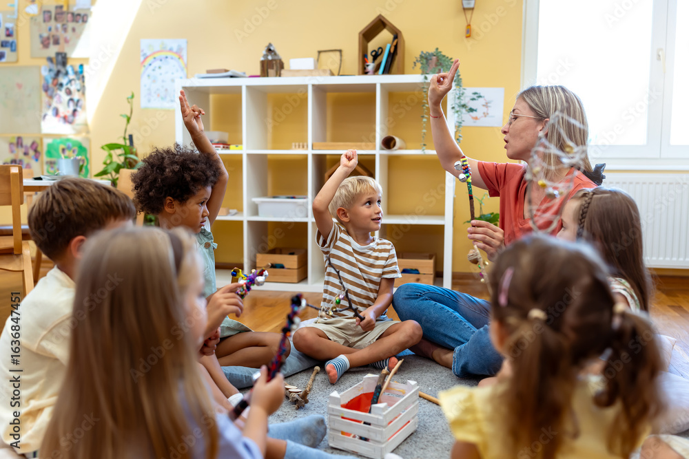 Obraz Preschool teacher leading interactive circle time, children raising hands and smiling during an engaging early learning activity