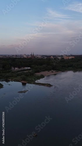 widok z drona w Warszawie na zilone części wybrzeża rzeki Wisła o zachodzie słońca