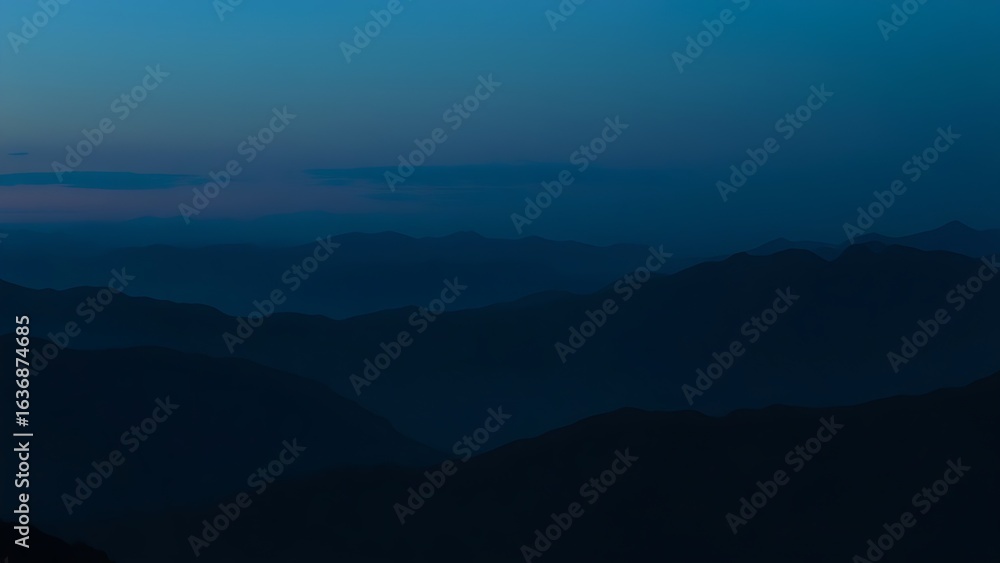 Fototapeta premium Silhouetted mountain range under a blue twilight sky, capturing a panoramic natural landscape.