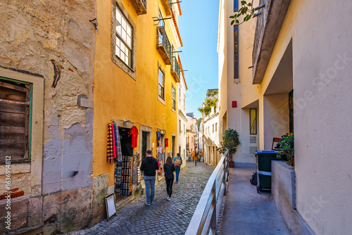 A narrow alley of shops in the colorful and historic Alfama district of Lisbon, Portugal.