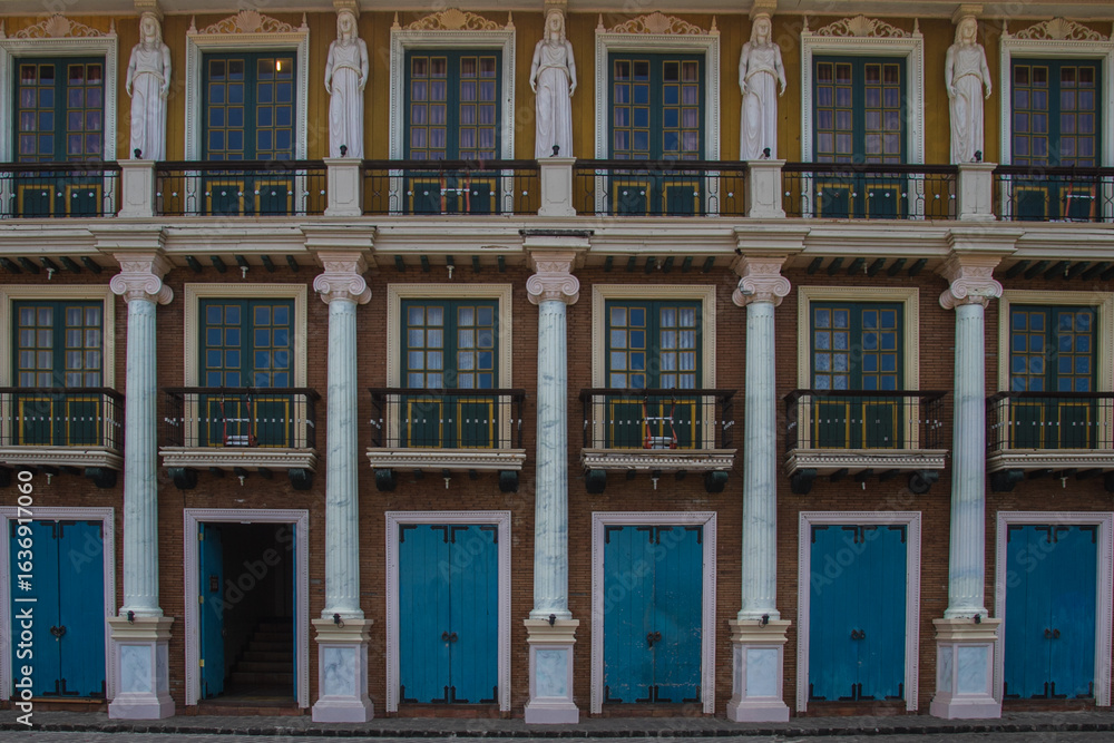Obraz premium Colorful Colonial-Style Building Facade with Blue Doors and Sculptures in the Philippines