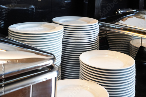Obraz na plátně Stack of white plates in a restaurant