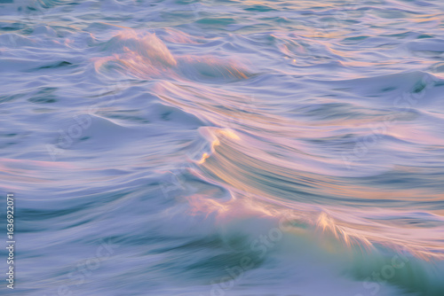 Soothing pastel waves glowing in the warm light of a tranquil sunrise, creating a serene and abstract seascape