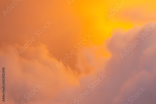 A serene skyscape with glowing orange and purple clouds during a beautiful sunset or sunrise
