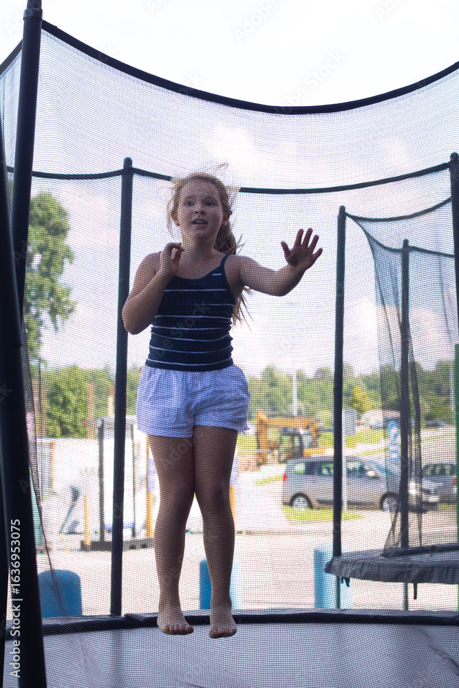 © Marina Chernivetskay - Girl Jumping on a Trampoline in Summer © Marina Chernivetskay - Girl Jumping on a Trampoline in Summer