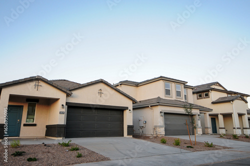 Schilderij op canvas Row of newly built suburban houses with attached garages in a new subdivision, r