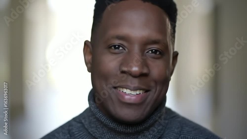 Close up portrait of a handsome African American man in a turtleneck smiling with confidence