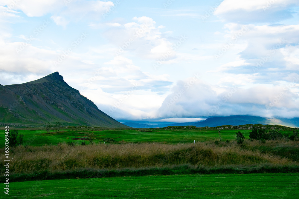Akrafjall Mountain and Green Fields Under a Cloudy Sky, Akranes, Iceland Akrafjall Mountain and Green Fields Under a Cloudy Sky, Akranes, Iceland