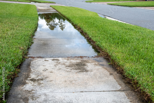Water Floods a Sidewalk in a Neighborhood After Rainstorm