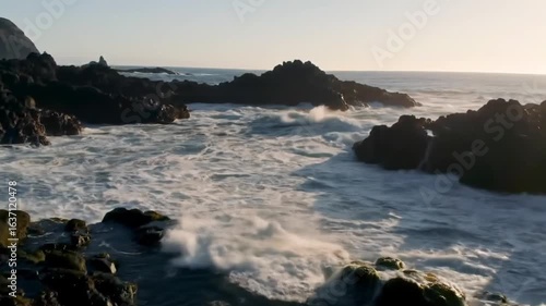 Dramatic Ocean Waves Crashing Against Rugged Rocks At Sunrise