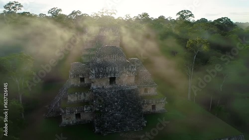 Ancient Mayan Structure Emerging From Jungle Mist At Sunrise