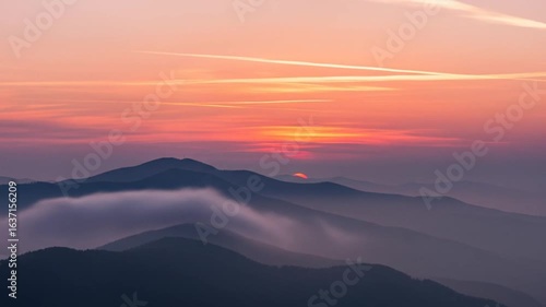 Wallpaper Mural Dramatic Orange Sunset Over Misty Mountain Range with Soft Clouds and Warm Golden Light Creating Tranquil Atmospheric Scenic Landscape Torontodigital.ca
