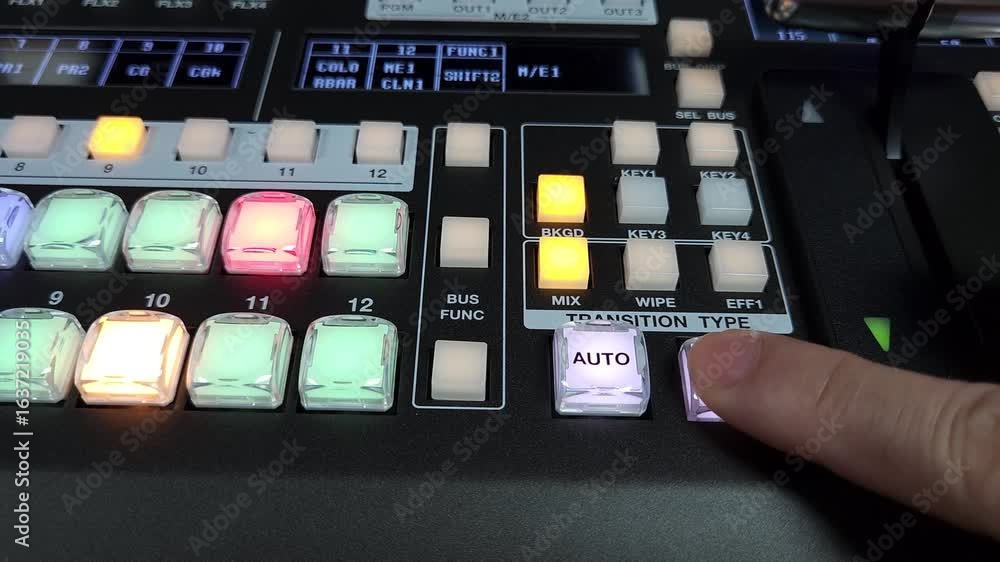 Close up of a video switcher control panel showing a hand pressing a ...