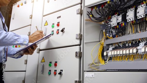 Foto Electrician checking electric current voltage at circuit breaker terminal and cable wiring main power distribution board AHU starter control panel and Electricity or electrical maintenance service