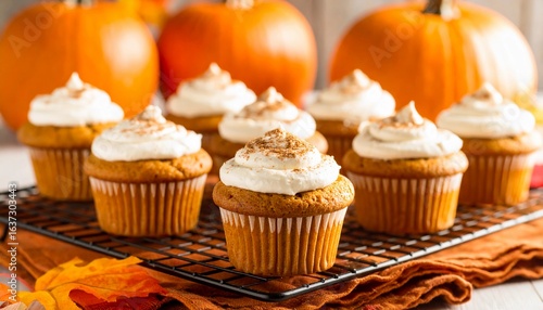 Fototapeta Naklejka Na Ścianę i Meble -  Indulge in delightful homemade pumpkin spice cupcakes topped with creamy frosting and a dusting of cinnamon, perfectly capturing the cozy essence of autumn celebrations and seasonal baking.