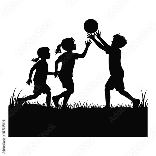 Silhouettes of three children playing catch with a ball in a grassy field at sunset