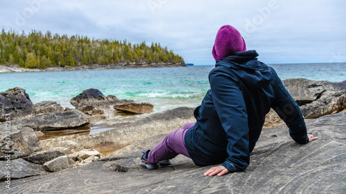 Person Relaxing on Rocky Shoreline at Little Cove, Tobermory, Ontario