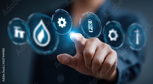 Close-up of a hand touching digital icons.  Businessperson interacts with holographic interface displaying energy/utility-related symbols