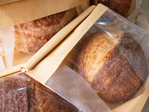 Sourdough Bread Loaf in Transparent Plastic Bag on White Background – Ready for Sale or Delivery