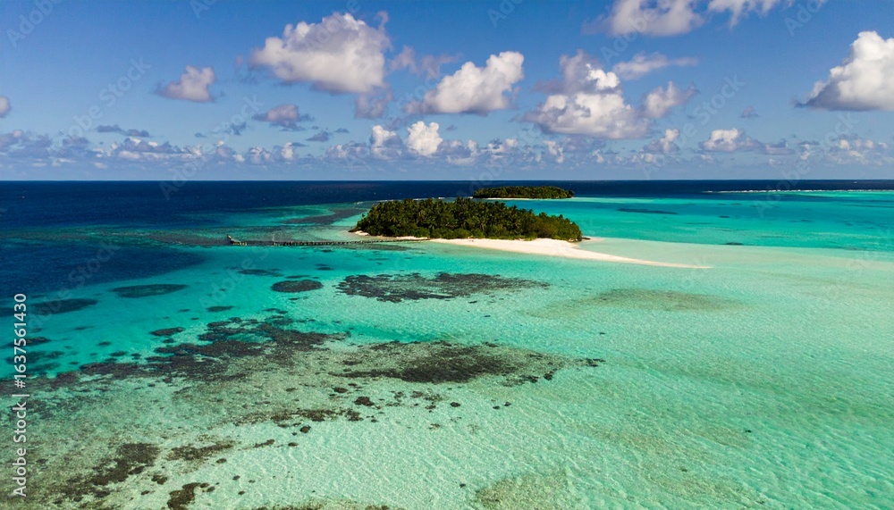 Obraz premium Aerial view of turquoise water surrounding small tropical islands, coral reefs visible beneath the surface