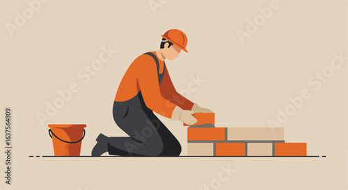 Bricklayer kneels, laying bricks for wall with orange bucket next to construction site