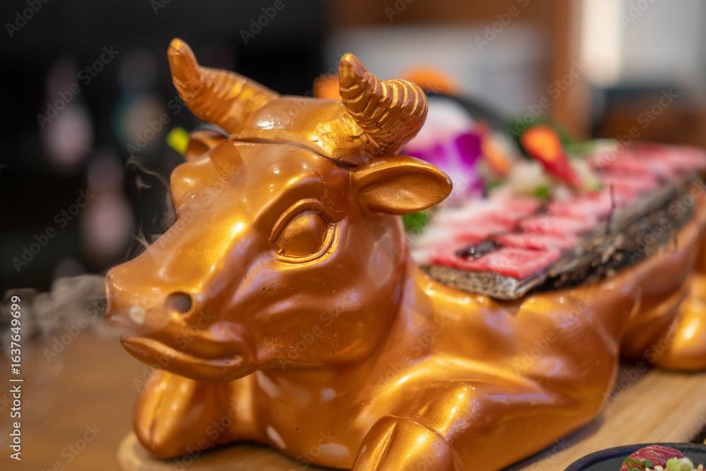 Fototapeta premium Golden cow shaped plate for Japanese style sliced wagyu beef.