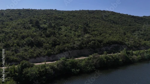 Ascending Verdant Slopes: Dynamic Drone Reveal of Boğazköy Dam Lake, Forested Mountains, and Winding Road in Bursa.