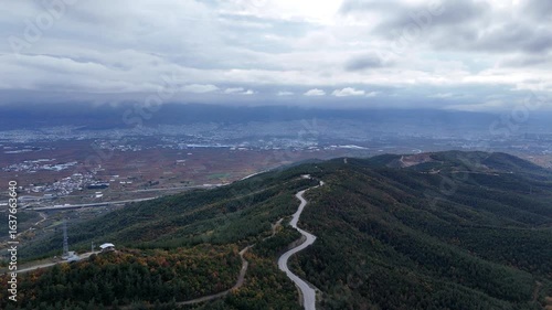 Majestic Mountain Road: A Drone's Sweeping Vista Over a Winding Route Through an Autumnal Forest