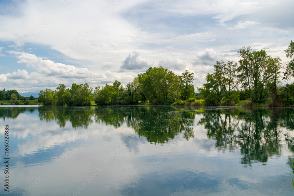 Obraz premium Lac de Bazet, France – Reflective Waters and Forested Shores.