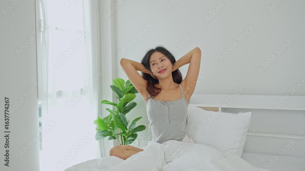 Young woman stretching in bright bedroom with natural light, relaxed morning atmosphere, feeling fresh after a good night’s sleep, serene lifestyle moment Young woman stretching in bright bedroom with natural light, relaxed morning atmosphere, feeling fresh after a good night’s sleep, serene lifestyle moment