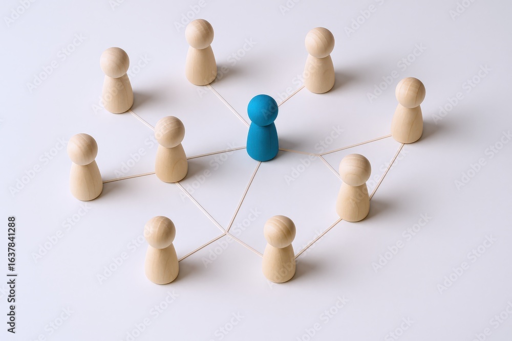 Obraz premium Wooden Figures Representing Network Connection, Leadership, and Teamwork with a Blue Figure in the Center