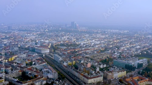 Wallpaper Mural 4K drone panorama of Vienna : red roofed districts, rail line and the Danube skyline with DC Tower rising in the haze - classic Central European cityscape in soft morning light. Torontodigital.ca