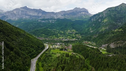 Aerial view approaching the Servoz town, cloudy, summer day in Alps, France