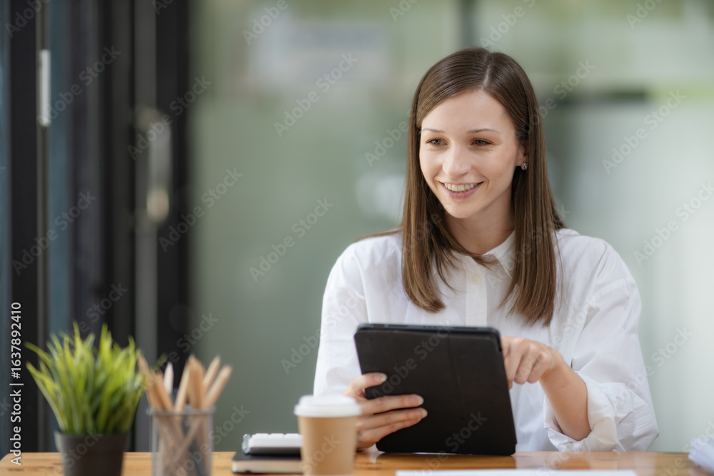 Obraz premium Businesswoman using a digital tablet while sitting in her office.
