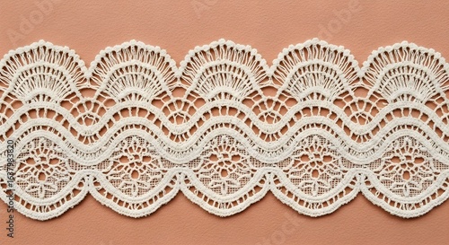 White decorative lace trim on peach background.