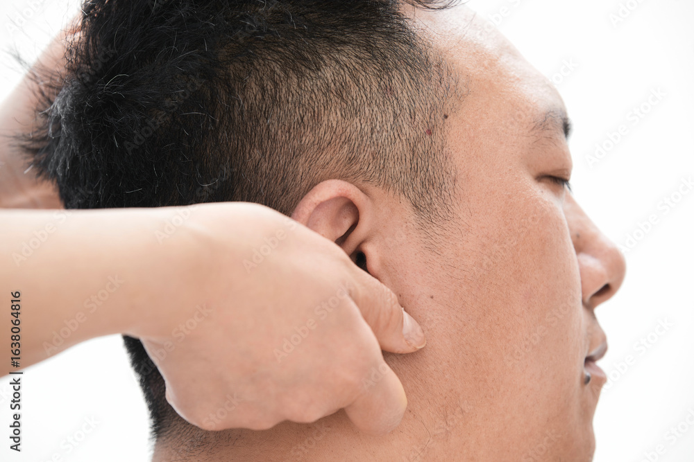 Naklejka premium A professional massage therapist gives a head massage to a man.