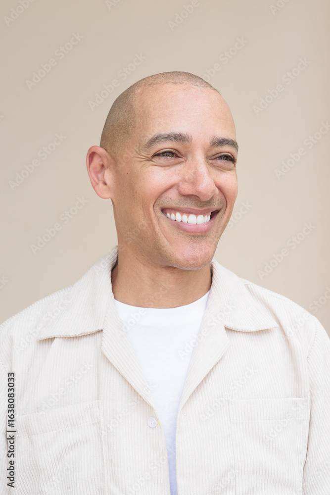 Fototapeta premium Bald Latin man face in casual shirt against beige background