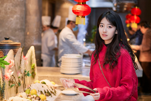 Fotografia A cute girl enjoying a hearty meal at the hotel buffet.
