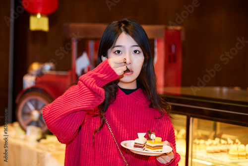 Canvas-taulu A cute girl enjoying a hearty meal at the hotel buffet.