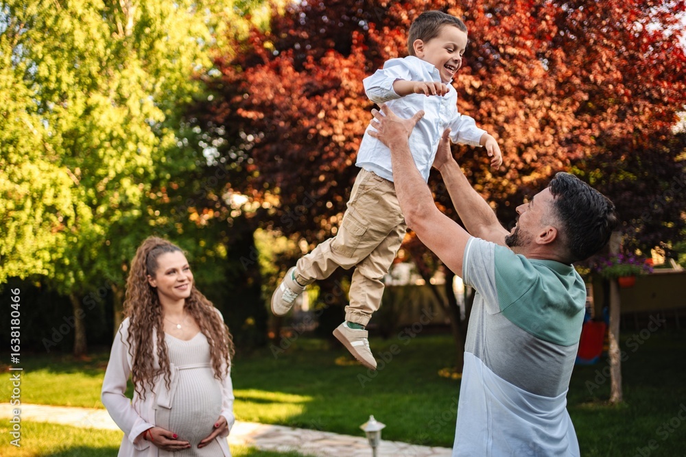Fototapeta premium Joyful family moment under blooming trees in springtime