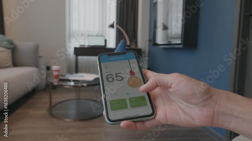 A person checks air quality levels on a smartphone in a modern living room, showcasing a smart home setup.