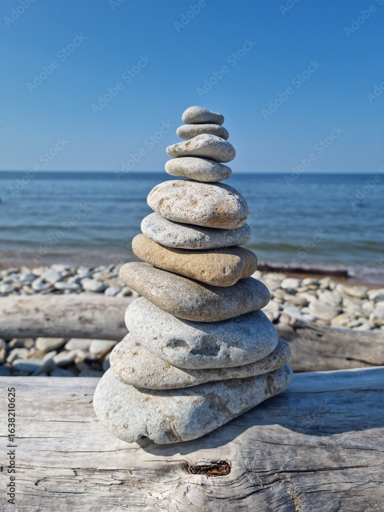 Fototapeta premium Zen Stone Stack on Driftwood at the Beach