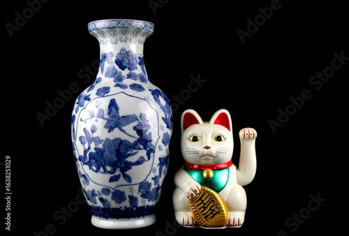 Oriental Blue and White Vase with White Waving Lucky Cat on a Black Background