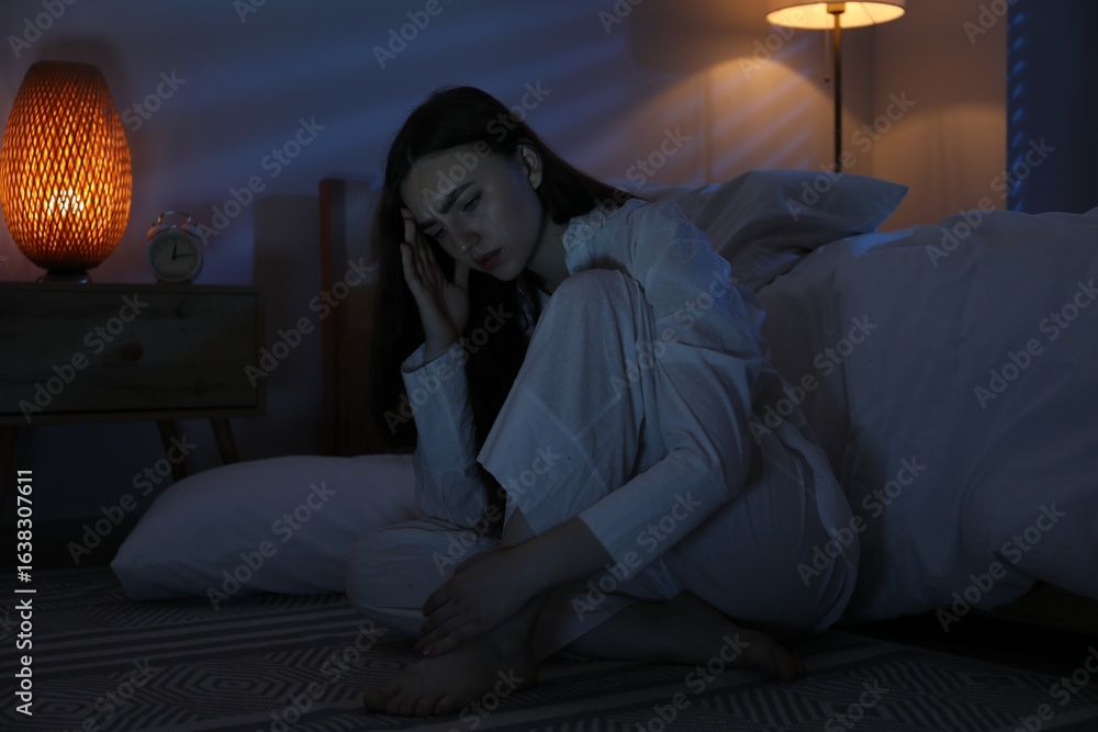Fototapeta premium Frustrated woman suffering from insomnia on floor at home