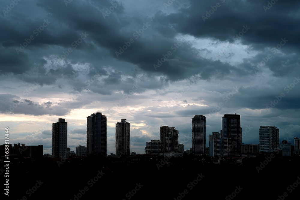 Fototapeta premium Dramatic stormy sky over a silhouetted cityscape at dusk with towering buildings