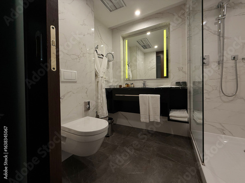 Minimalist bathroom interior in hotel featuring shower, toilet, and sink. Concise modern bathroom design concept. Handheld mobile photo, selective focus, non AI