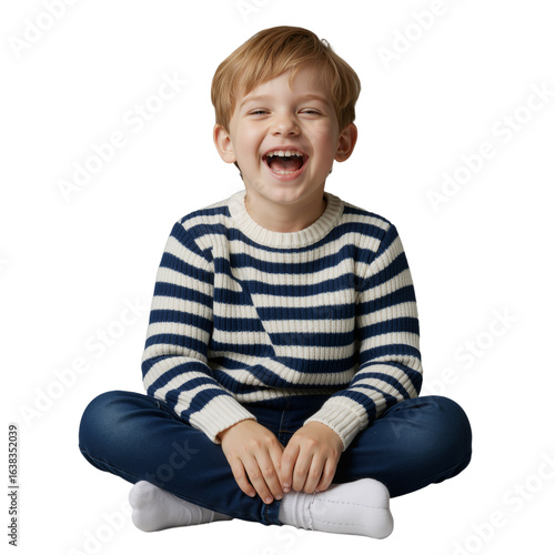 A cheerful blond boy in a striped sweater laughing with pure joy while sitting isolated on a white background.